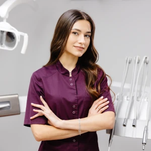 Cosmetic dentist in Linden standing with arms crossed near dental equipment in the exam room